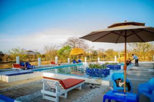 a swimming pool with chairs and an umbrella at Angel homestay hotel in Mikumi