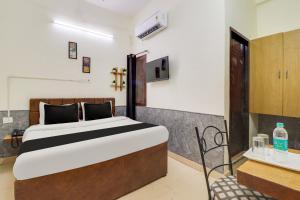 a bedroom with a bed and a table and a chair at Hotel O Second Home Residency in Dehradun