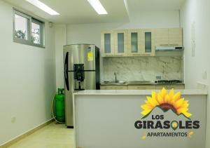 une cuisine avec un réfrigérateur orné d'un tournesol dans l'établissement Los Girasoles Apartamentos, à Pueblo Bello