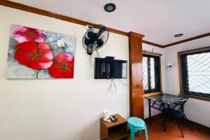 Habitación con 2 cuadros en la pared y una mesa. en Mountain Transient Lodge, en Baguio