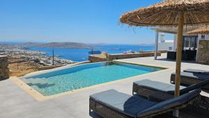 ein Schwimmbecken mit Stühlen und einem Sonnenschirm in der Unterkunft Aether Mykonos 3BR Villa with Serene Port & Town Views in Tourlos