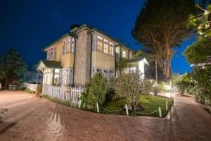 a large house at night with a white fence at Windamere Hotel - A Colonial Heritage Since 1841 in Darjeeling