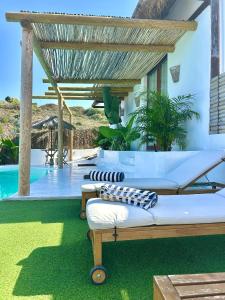 un patio con tre letti e una piscina di Villa Ocean Breeze a Firgas