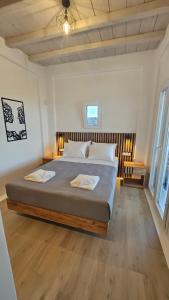 ein Schlafzimmer mit einem großen Bett mit Holzboden in der Unterkunft Aether Mykonos 3BR Villa with Serene Port & Town Views in Tourlos + 42 Fotos