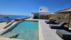 einen Pool an der Seite einer Villa in der Unterkunft Aether Mykonos 3BR Villa with Serene Port & Town Views in Tourlos