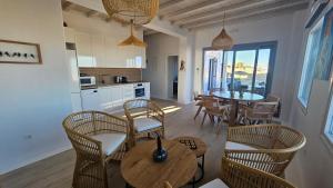 eine Küche und ein Esszimmer mit Tisch und Stühlen in der Unterkunft Aether Mykonos 3BR Villa with Serene Port & Town Views in Tourlos