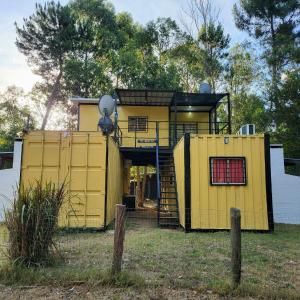 una casa gialla con una finestra rossa in un cortile di Guazubira a Guazuvirá