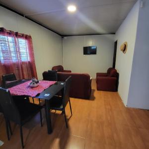 una sala da pranzo con tavolo, sedie e divano di Guazubira a Guazuvirá