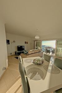 een eetkamer en woonkamer met een tafel en stoelen bij Ericeira Sunset Apartment in Ericeira