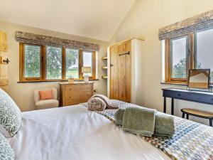 a bedroom with a bed and a desk and windows at 1 Bed in Leominster 95609 in Pencombe