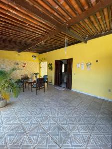 纳塔尔Casa em Cidade Verde - Nova Parnamirim的一个户外露台，摆放着桌椅，还有一面黄色的墙。