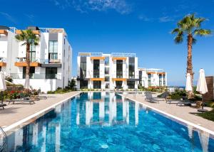 KharchaにあるAzra Suite By HolidayKeysのヤシの木が茂る建物の前にあるスイミングプール