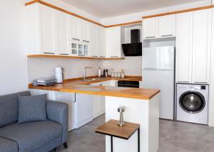 KharchaにあるAzra Suite By HolidayKeysの白いキャビネット、シンク、冷蔵庫付きのキッチンが備わります。