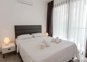 KharchaにあるAzra Suite By HolidayKeysのタオルが敷かれた大きな白いベッドのある寝室 +15枚の写真