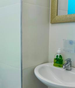 a bathroom with a sink and a bottle of soap at Hospedaje Torices Cartagena in Cartagena de Indias