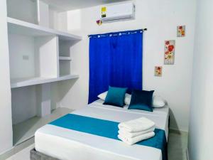a bedroom with a bed with a blue curtain at Hospedaje Torices Cartagena in Cartagena de Indias
