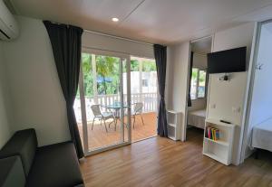 Zimmer mit einem Bett, einem Tisch und einem Balkon in der Unterkunft Bungalow e Mobilhome - Camper Park 2 in Rimini