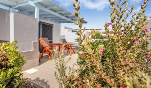 a patio with a table and chairs and flowers at Apartamentos LIVVO Mar Azul - Adults Only in Corralejo