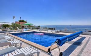 una piscina con un tobogán azul frente al océano en Seaside Apartments, en Split