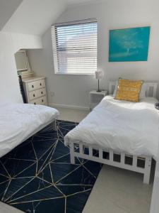a bedroom with two twin beds and a window at Stylish beachside Gem in Fish Hoek in Fish Hoek +15 photos