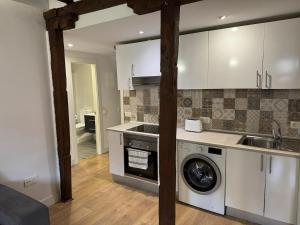 una cocina con lavadora, fregadero y lavadora en Andimi Don Diego #2, en Toledo