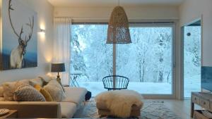 ein Wohnzimmer mit Couch und großem Fenster in der Unterkunft Arctic Luxury Home in Rovaniemi