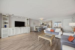 a living room with a couch and a tv at Beach Cottage Look Condo, Ocean View from Spacious Balcony in Fernandina Beach