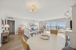 a dining room and living room with a table and chairs at Beach Cottage Look Condo, Ocean View from Spacious Balcony in Fernandina Beach +37 photos