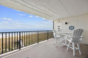 a balcony with a table and chairs and the ocean at Beach Cottage Look Condo, Ocean View from Spacious Balcony in Fernandina Beach