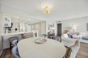 a kitchen and living room with a white table and chairs at Beach Cottage Look Condo, Ocean View from Spacious Balcony in Fernandina Beach