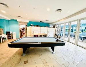 un tavolo da biliardo in una grande stanza con finestre di Vortex klcc luxury suits by MN a Kuala Lumpur Altre 6 foto