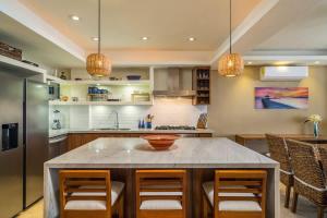 una cucina con isola, sedie e piano di lavoro di Luxury Beachfront Condo Punta Mita a Punta Mita