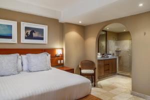 una camera da letto con un letto e un bagno di Luxury Beachfront Condo Punta Mita a Punta Mita