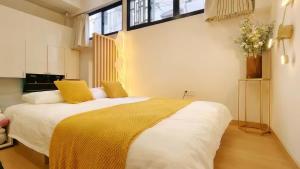 a bedroom with a large white bed with yellow pillows at Shanghai Hills & Aromahome UrbanLuxe Family bnb close to Mid Huaihai rd in Shanghai