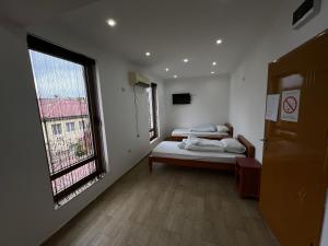 Un dormitorio con dos camas y una gran ventana. en G-CITY Hostel, en Subotica