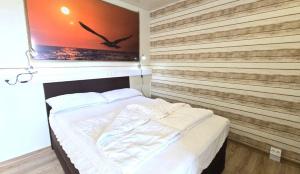 ein Bett in einem Zimmer mit einer Holzwand in der Unterkunft Ferienwohnung Möwe in Schönberg