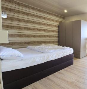 ein Bett in einem Zimmer mit einer Holzwand in der Unterkunft Ferienwohnung Möwe in Schönberg