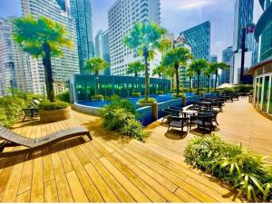 un ponte con tavoli, sedie e palme in una città di Vortex klcc luxury suits by MN a Kuala Lumpur