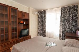 1 dormitorio con 1 cama, TV y cortinas en Luxury 1-bd Apartment Novomestenska Street, en Sumy