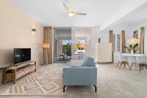 a living room with a blue chair and a tv at Kasa Blou in Kralendijk