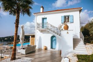 a white house with a balcony and a swimming pool at Luxury Apartments La Villa in Chorto