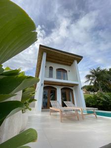 a house with a bench in front of it at Native Villa with Pool at Kalumo Lodge in Oslob