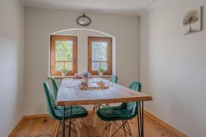ein Esszimmer mit einem Holztisch und grünen Stühlen in der Unterkunft Vila Trate in Noršinci pri Ljutomeru + 62 Fotos