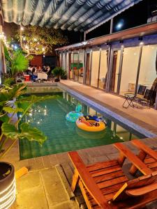 a swimming pool with two inflatables in a house at Villa Phước Nguyên in Ấp Bình Hưng +15 photos