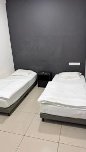 due letti uno accanto all'altro in una stanza di Syt Hotel a Banting