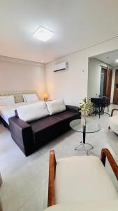 um quarto com duas camas, uma mesa e um sofá em Ilê de Pipa Blz em Pipa