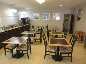 a restaurant with wooden tables and chairs and a counter at Best Western Champions Forest Inn and Suites in Houston