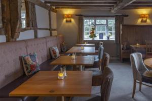 a restaurant with wooden tables and chairs and a window at Kings Court Hotel Alcester, BW Signature Collection in Stratford-upon-Avon
