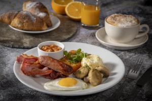 a plate of breakfast food with eggs bacon and bread at Kings Court Hotel Alcester, BW Signature Collection in Stratford-upon-Avon