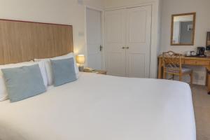 a bedroom with a large bed with blue pillows at Kings Court Hotel Alcester, BW Signature Collection in Stratford-upon-Avon